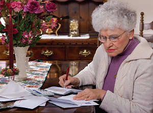 Elderly woman handlilng her bills